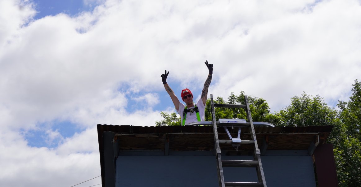 Solar Volunteer Team Peace Signs on Roof Solar Volunteer Team Peace Signs on Roof